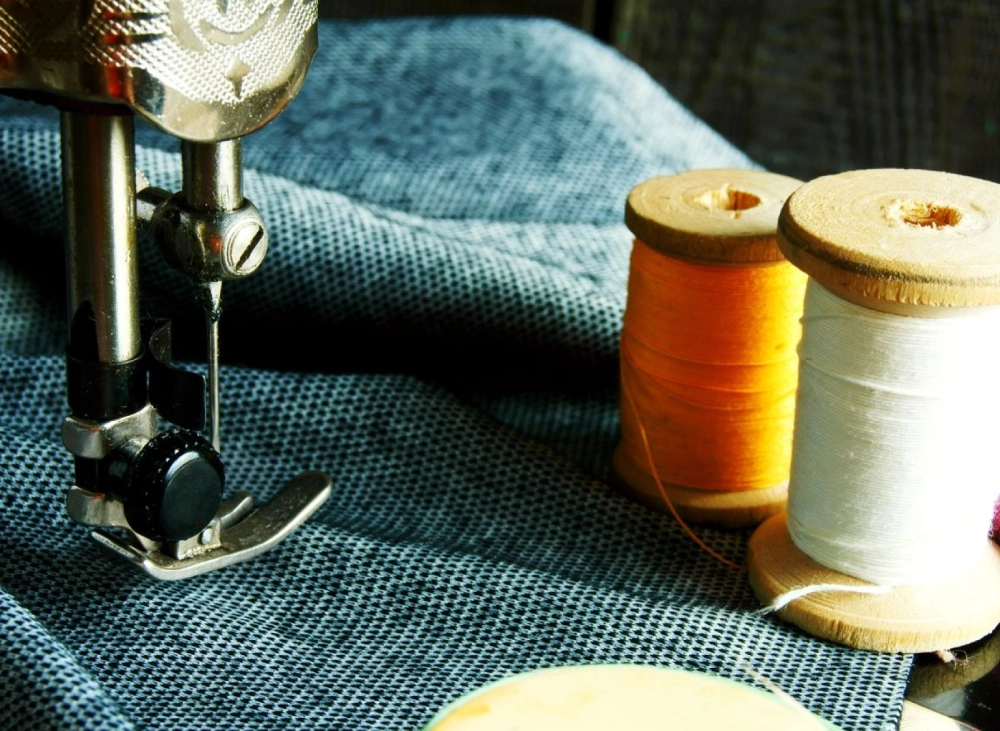 A sewing machine and thread on a table.